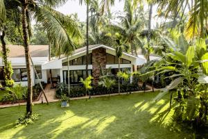 戴维格Coco Palms Resort, Diveagar的一栋门前有棕榈树的房子