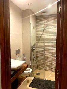 een badkamer met een douche, een toilet en een wastafel bij Appartement avec piscine et jacuzzi privé in Casablanca