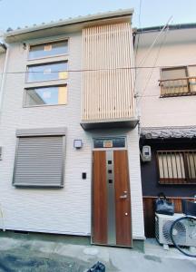 una casa con una puerta marrón y una ventana en Linn 阿倍野 en Osaka