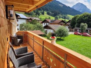 einen Balkon mit Stühlen und Bergblick in der Unterkunft FERIENHAUS AM DORFBRUNNEN in Oberstdorf