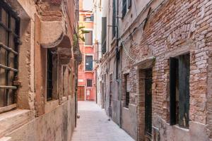 um beco numa cidade antiga com edifícios de tijolos em Ca' Nova @San Marco em Veneza