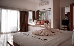 una camera da letto con un grande letto con un vestito sopra di MAHAMAYA Gili Meno a Gili Meno Altre 55 foto