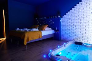 Carpe Diem - Le Domaine Wambrechies في Wambrechies: غرفة نوم زرقاء مع سرير وحوض استحمام