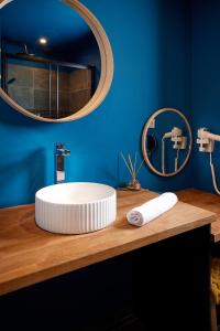 La salle de bains est pourvue d'un lavabo blanc et d'un miroir. dans l'établissement Carpe Diem - Le Domaine Wambrechies, à Wambrechies