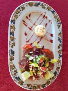 un plato de comida con carne y verduras en una mesa en Agriturismo Le Due Cascine, en San Marzano Oliveto