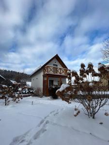 U Gruszków - domek pod Chojnikiem في يلينيا غورا: منزل فيه ثلج على الأرض أمامه