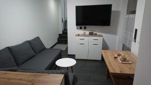una sala de estar con un sofá y una mesa en Ferienwohnung Haus Merle, en Jestädt