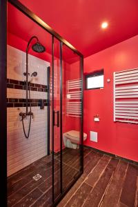 a red bathroom with a shower and a toilet at L'INDUS - Le Domaine Wambrechies in Wambrechies