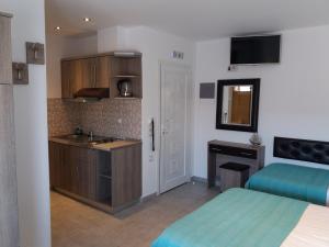 a room with two beds and a sink and a kitchen at AZALEA HOTEL in Sarti