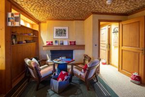 a room with a table and chairs and a fireplace at Magic Megève Bois in Demi-Quartier