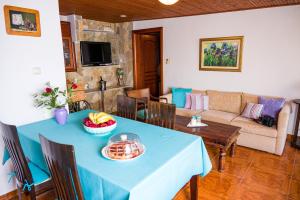 - un salon avec une table bleue et un canapé dans l'établissement Zoina's House, à Leptokaryá
