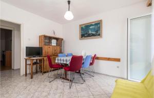 ein Esszimmer mit einem Tisch und roten und blauen Stühlen in der Unterkunft Nice Apartment In Bosana-pag With Wifi in Šimuni