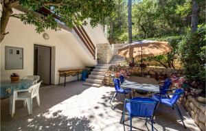 a patio with a table and chairs and an umbrella at Nice Apartment In Bosana-pag With Wifi in Šimuni