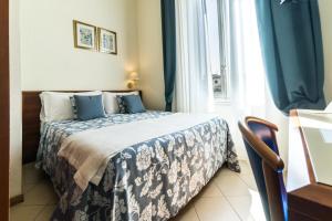 ein Schlafzimmer mit einem Bett mit einer blauen und weißen Decke in der Unterkunft Hotel Bonifacio in Florenz