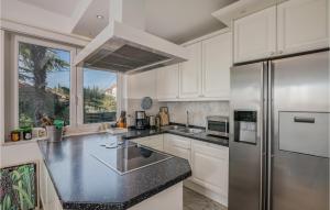 a kitchen with white cabinets and a stainless steel refrigerator at Nice Home In Njivice With Wifi in Njivice