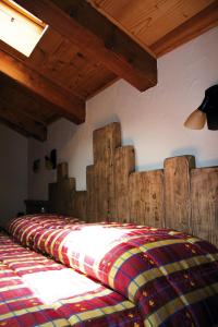 a bed with a wooden headboard in a room at Green Hotel Herbetet in Cogne