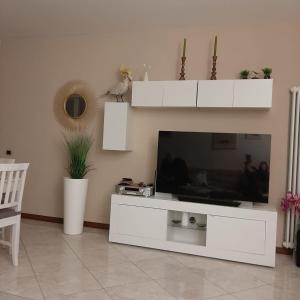 a living room with a large white entertainment center with a television at Appartamento GIRASOLE, Salò in Salò
