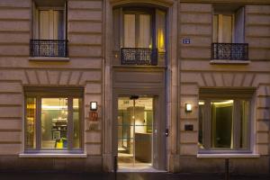 fachada de un edificio con ventanas y luces en Hôtel Sophie Germain, en París