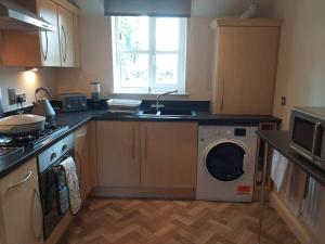 a kitchen with a washing machine and a sink at No 8 in Kington