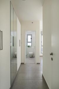 uma casa de banho com 2 WC e uma porta de vidro em Deluxe & Terrace with City Overview by FeelHome em Holon