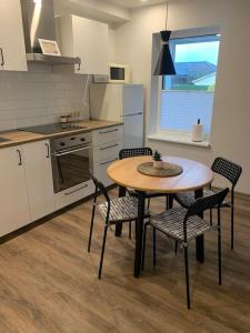 a kitchen with a table and chairs in a kitchen at Cozy apartment in Karmelava in Karmėlava