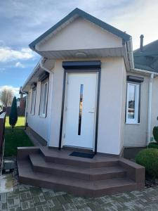 uma casa com uma porta branca e escadas em frente em Cozy apartment in Karmelava em Karmėlava