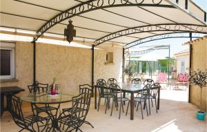ロシュフォール・デュ・ガルにあるAwesome Home In Rochefort Du Gard With 4 Bedrooms, Wifi And Outdoor Swimming Poolの開閉式屋根の下にテーブルと椅子付きのパティオ