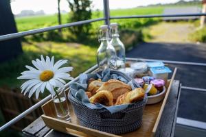 Spa privatif à la ferme - Haut de gamme - Atypique في Bois-Grenier: طاولة نزهة مع سلة من الخبز و ديزي