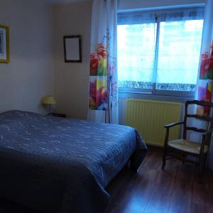 - une chambre avec un lit, une fenêtre et une chaise dans l'établissement Chambre d'hôtes dans Résidence, à Dijon