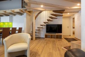 sala de estar con escalera y TV en Apartments Alpenrose en Saas-Almagell