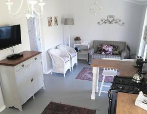 a living room with a couch and a table at Rose Cottage AtTheDairyShed in Heidelberg