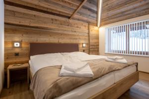 サース・アルマゲルにあるApartments Alpenroseの木製の壁のベッドルーム1室(大型ベッド1台付)