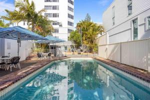 a swimming pool next to a building with a building at Beachfront Luna Apartment in Gold Coast
