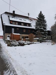 a house with snow on the ground in front of it at Ferienwohnung Harmonie in Bad Teinach-Zavelstein