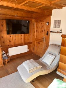 a living room with a large flat screen tv at Bambi Lodge Ferienwohnung auf knapp 1400 m nahe Arosa in Peist