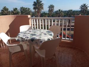un tavolo e sedie su un balcone con vista sull'oceano di COMFORT SUITE La Manga, marina & beach a La Manga del Mar Menor