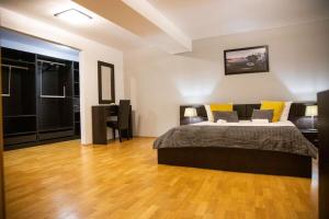 um quarto com uma cama e piso em madeira em Duplex 145mp, 2+1 camere, 3 bai em Mogoşoaia