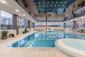 a large swimming pool in a large building at Apartament Holiday 8/25 in Rewal