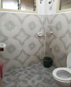 a bathroom with a toilet and a tiled wall at The Sylvia in San Juan
