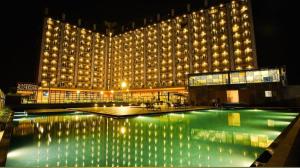 ein großes Gebäude mit Swimmingpool in der Nacht in der Unterkunft Weekend address homestay by shan in Surat