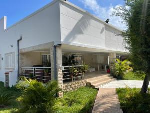 a white house with a porch and stairs to it at Casa Luxuosa na Ilha do Mussulo in Belas