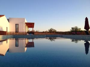 a villa with a swimming pool next to a house at Quinta de São Gabriel in Castro Marim +38 photos