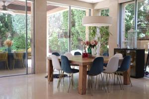 comedor con mesa de madera y sillas en The Peaceful Villa en Herzelia 