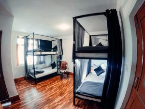 a room with two bunk beds and a wooden floor at Roamate Hostel, Old Manali in Manāli