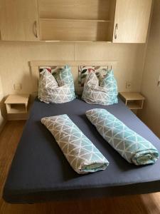 una cama azul con almohadas encima en Märchencamping, en Stuhr