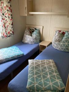 ein Zimmer mit zwei Betten, bezogen mit blauen Laken und Kissen. in der Unterkunft Märchencamping in Stuhr + 72 Fotos
