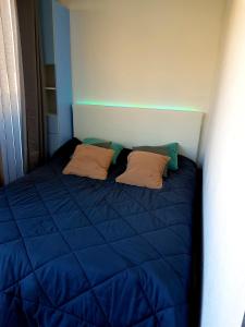 Una cama azul con dos almohadas encima. en Studio moderne classe 2 dans marina proche mer et etang - lit wifi fibre et parking privé, en Sète