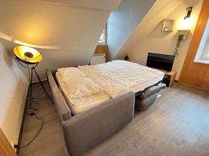 a small bedroom with a bed and a lamp at Le Coeur de Pontarlier in Pontarlier