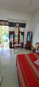 a bedroom with a bed and a mirror and windows at Wimala B&B in Bentota