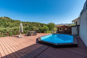 a swimming pool on a deck with a table and a patio at A sérénita in Carbuccia